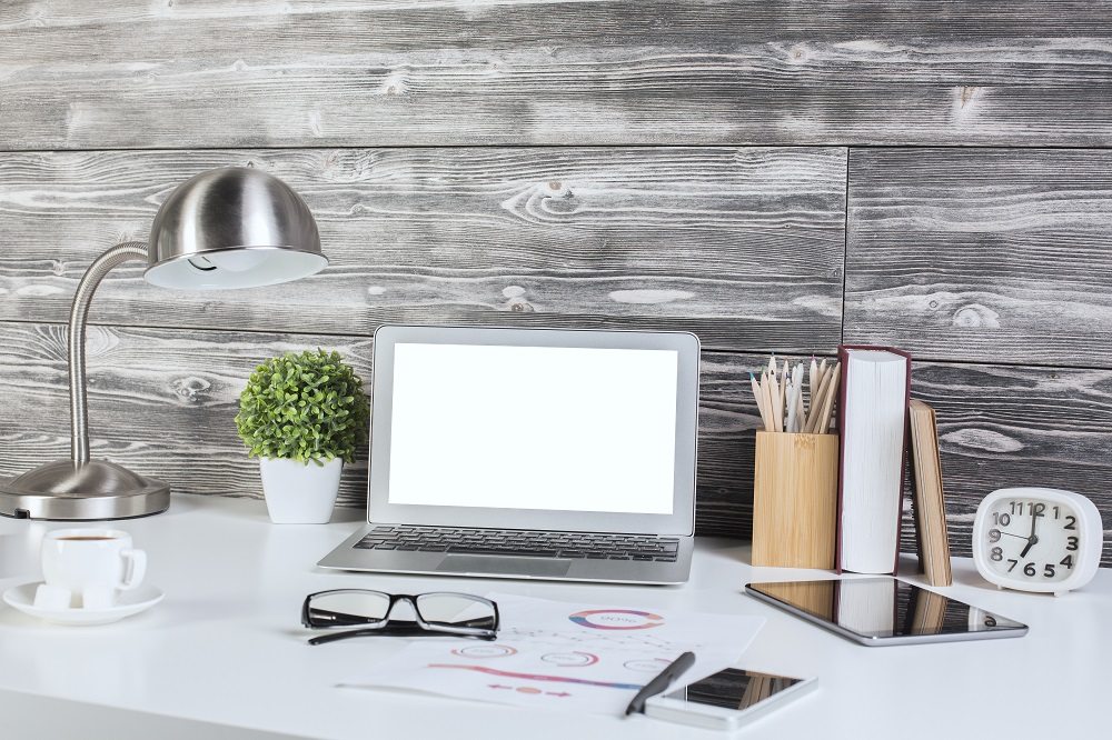 Creative office desktop with blank white laptop